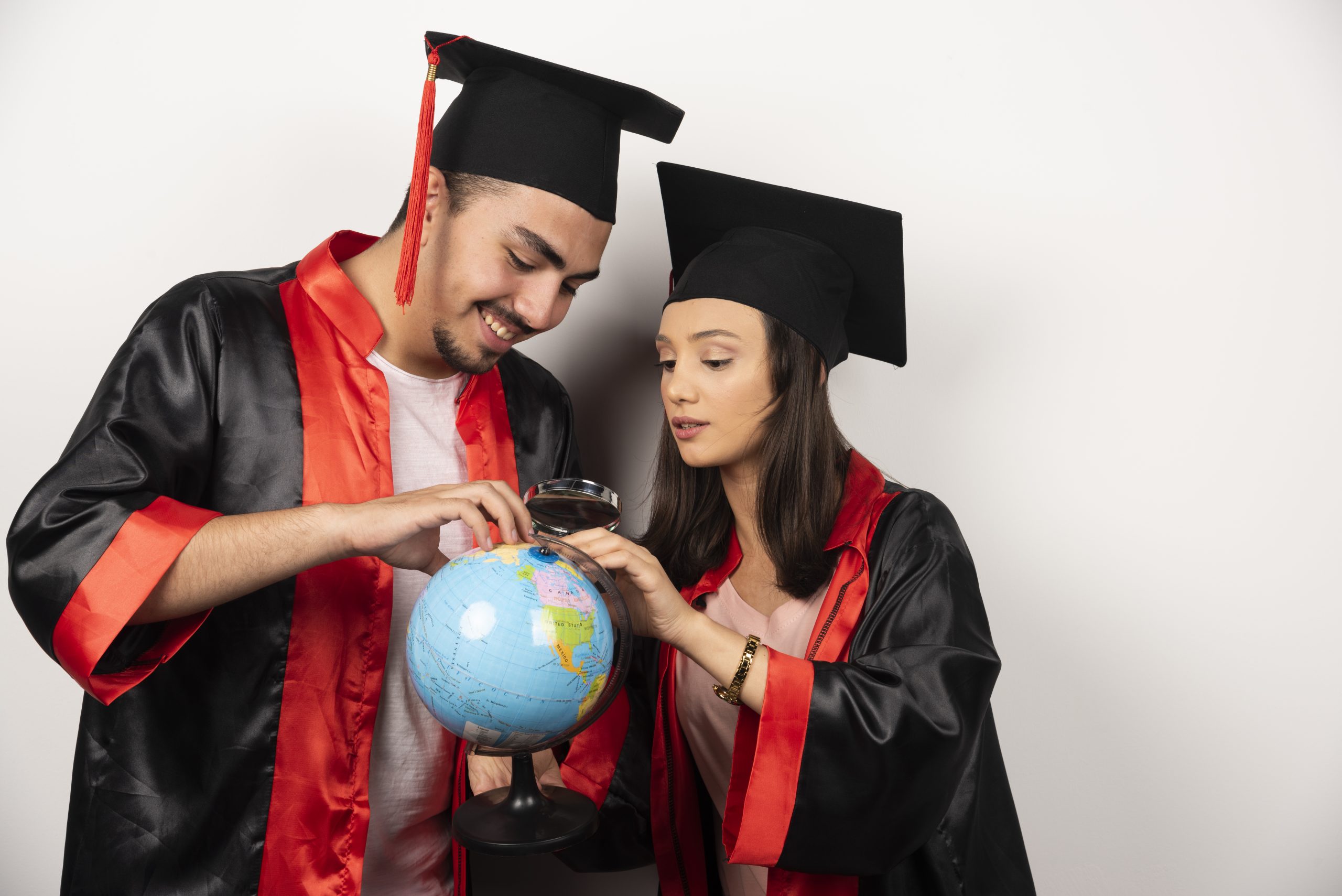 Indian students in graduation gowns exploring study abroad opportunities with globe